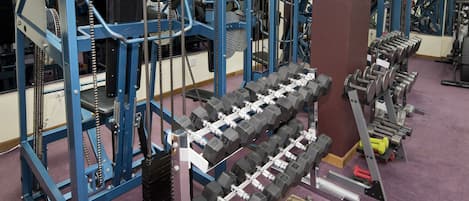 A gym with weightlifting equipment, including dumbbells and weight plates.