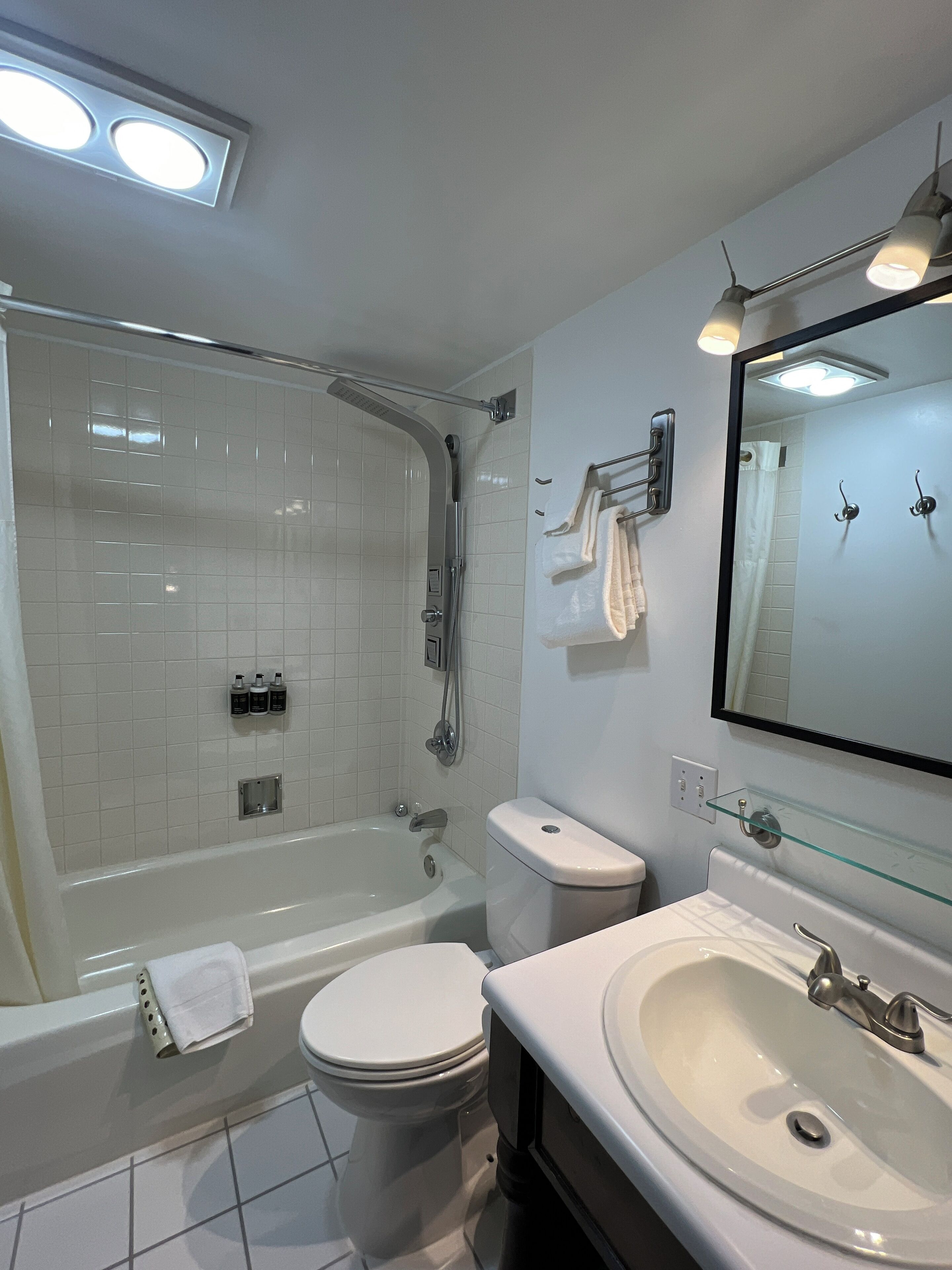 A modern bathroom with a bathtub, toilet, and sink.