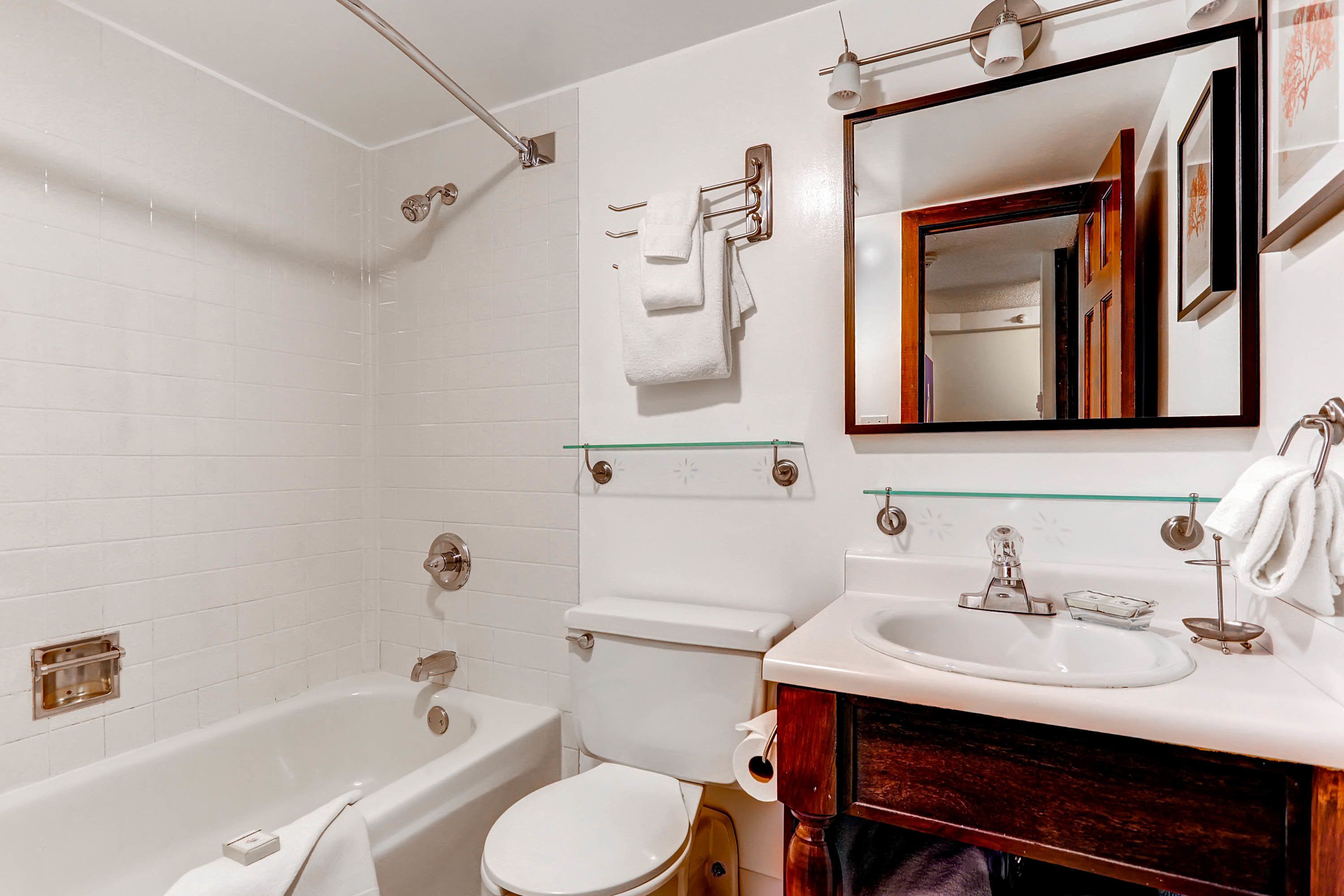 A modern bathroom with a bathtub, toilet, and sink.