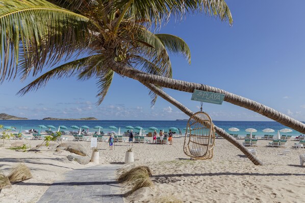 Am Strand, weißer Sandstrand, Liegestühle, Sonnenschirme