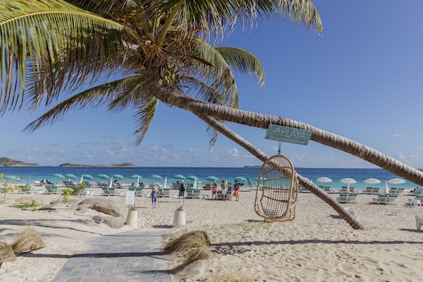 På stranden, vit sandstrand, solstolar och parasoller