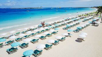 En la playa, playa de arena blanca, camastros y sombrillas