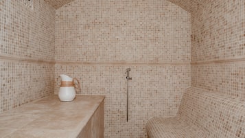 Relax in a bathroom with a mosaic tile design, featuring a showerhead and a curved bench with seating.