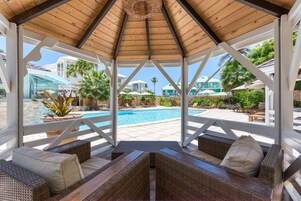 Una piscina al aire libre, sillones reclinables de piscina