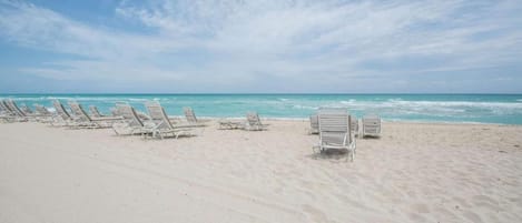 On the beach, white sand, sun-loungers, beach umbrellas