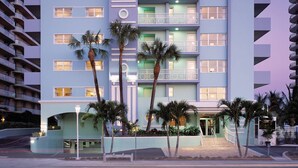 Ein mehrstöckiges Hotel mit Balkonen, Palmen und modernem architektonischen Design.