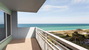 Ein Balkon mit Blick auf Strand und Meer.