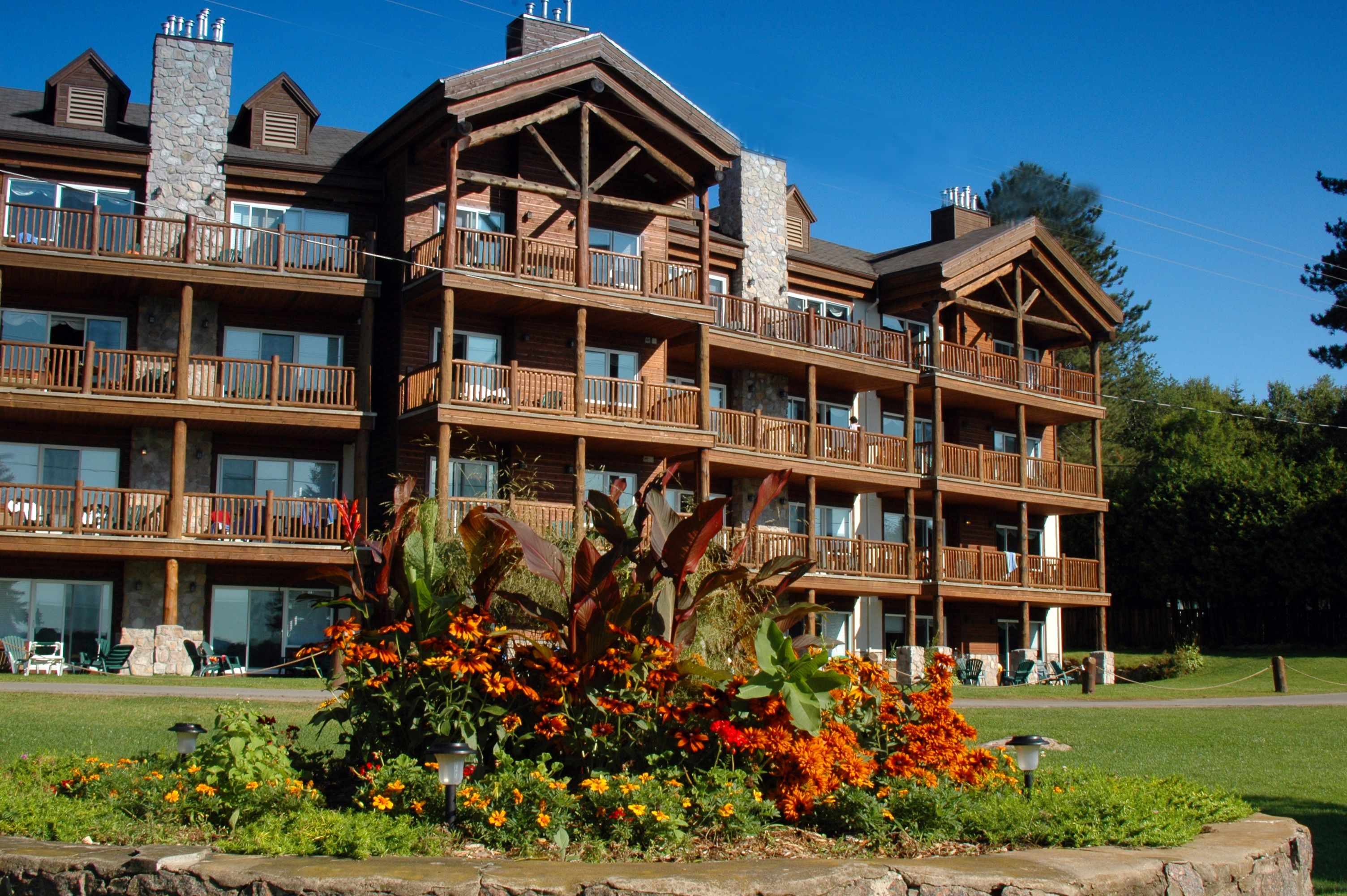 Un chalet à étages doté de balcons et de grandes fenêtres.