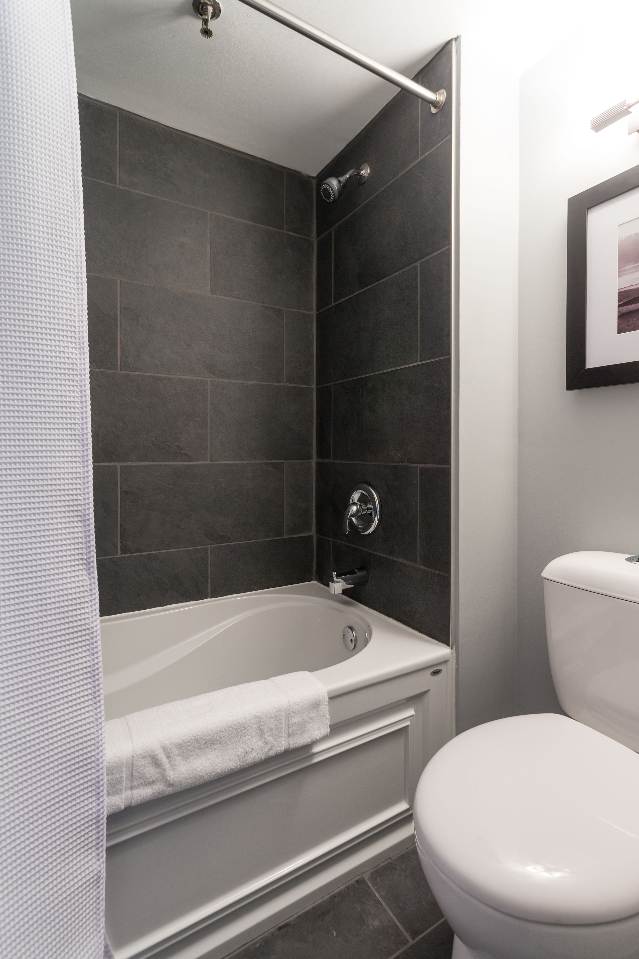 Ein modernes Badezimmer mit Badewanne, Toilette und separater Duschkabine.