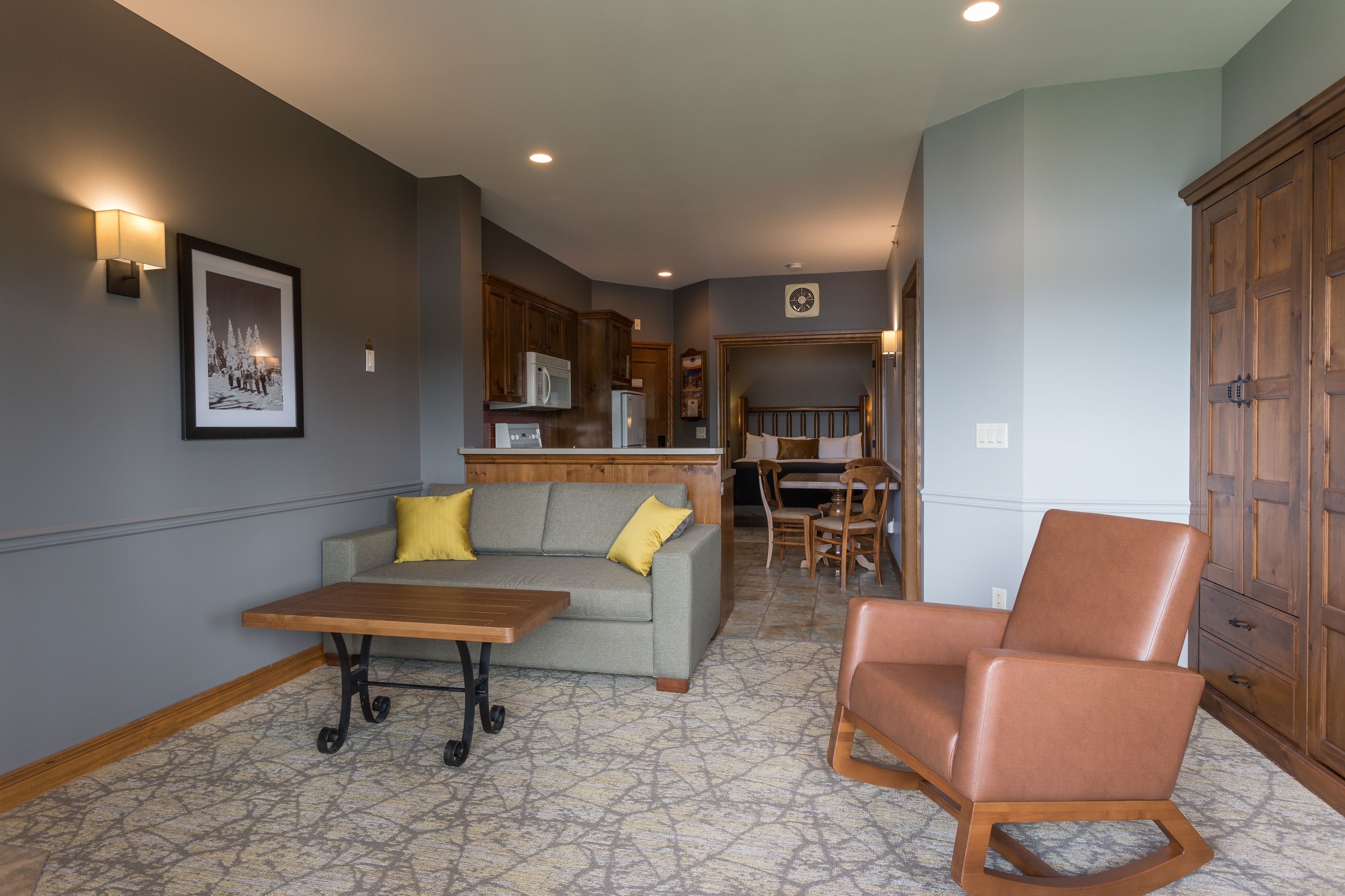 A living room with a sofa, a wooden coffee table, and a rocking chair.