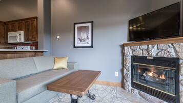 A living room with a fireplace, a television, a sofa, and a coffee table.