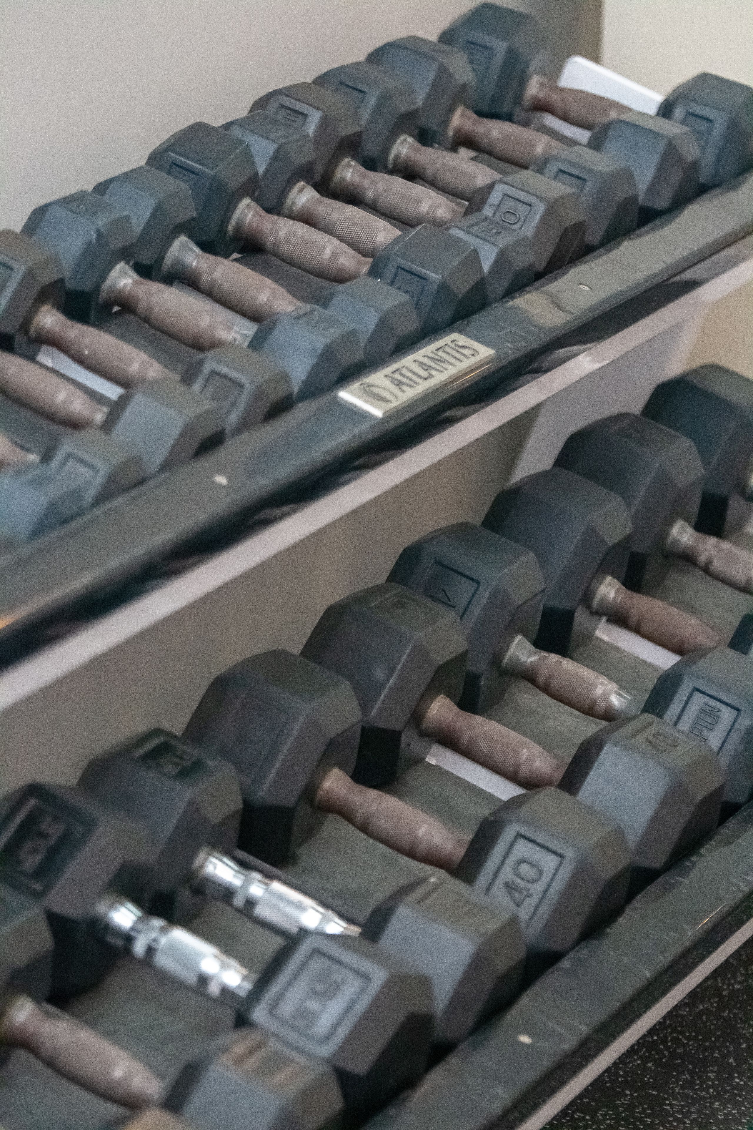 A rack of dumbbells with weight markings, arranged in rows.
