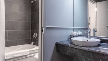 Un baño moderno con bañera, lavamanos y zona de ducha.