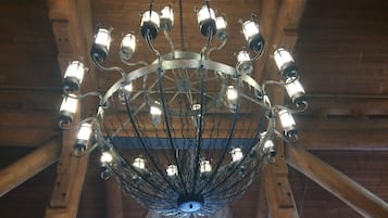 Un lustre composé de plusieurs ampoules suspendues à une structure métallique, agrémenté d’un élément décoratif central.