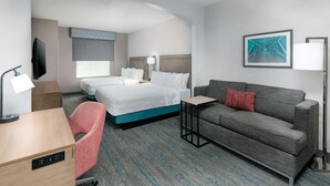 A hotel room with a bed, a sofa, a desk, and a TV. - Hampton Inn Boston Bedford Burlington (Billerica)