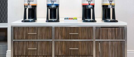 A coffee station with four dispensers labeled Decaf Roast, Dark Roast, Hot Water, and Light Roast.