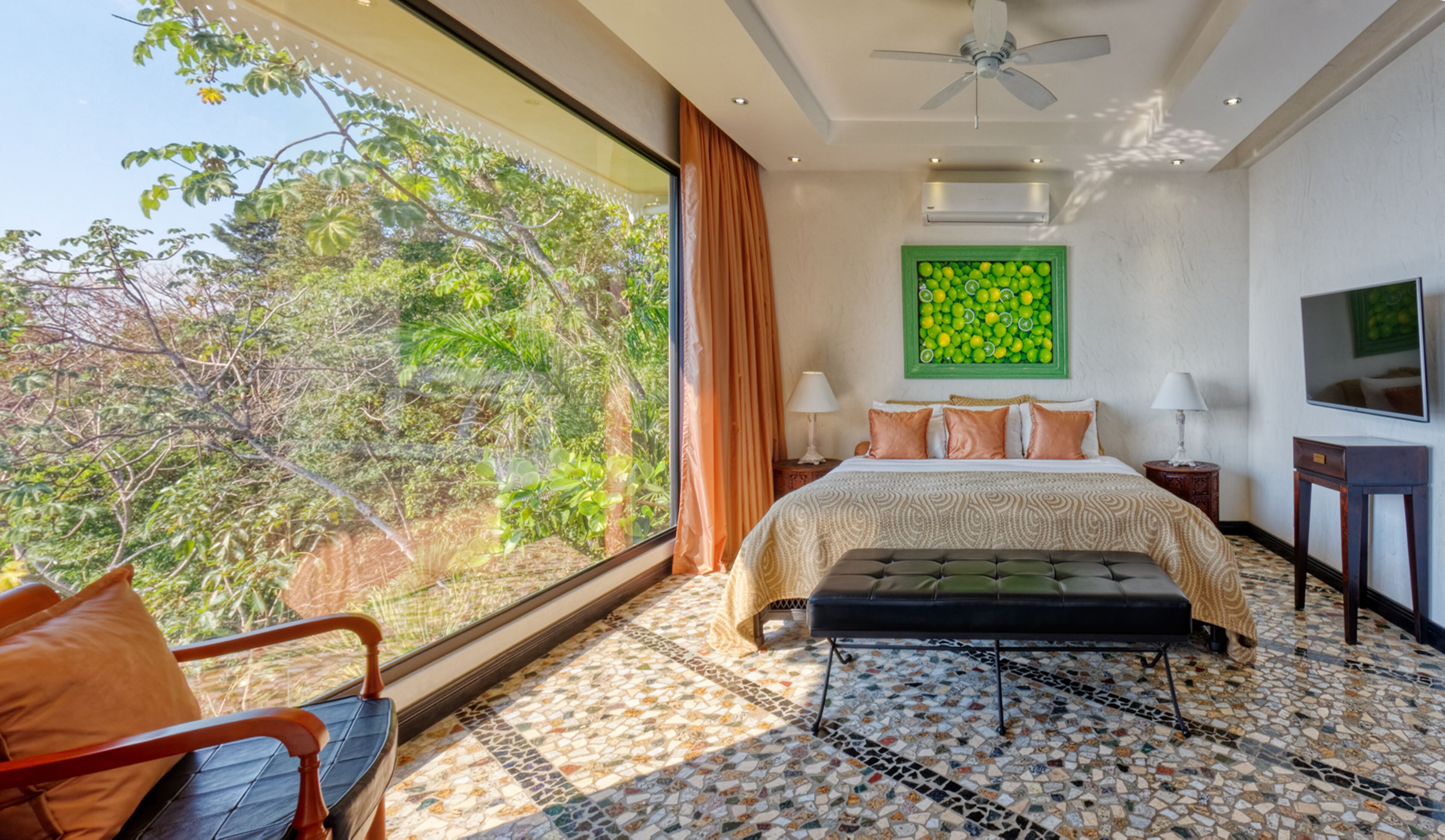 A modern bedroom with a large window, a bed, a TV, and a ceiling fan.