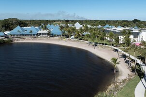 A coastal resort with beach access, palm trees, and blue-roofed buildings.