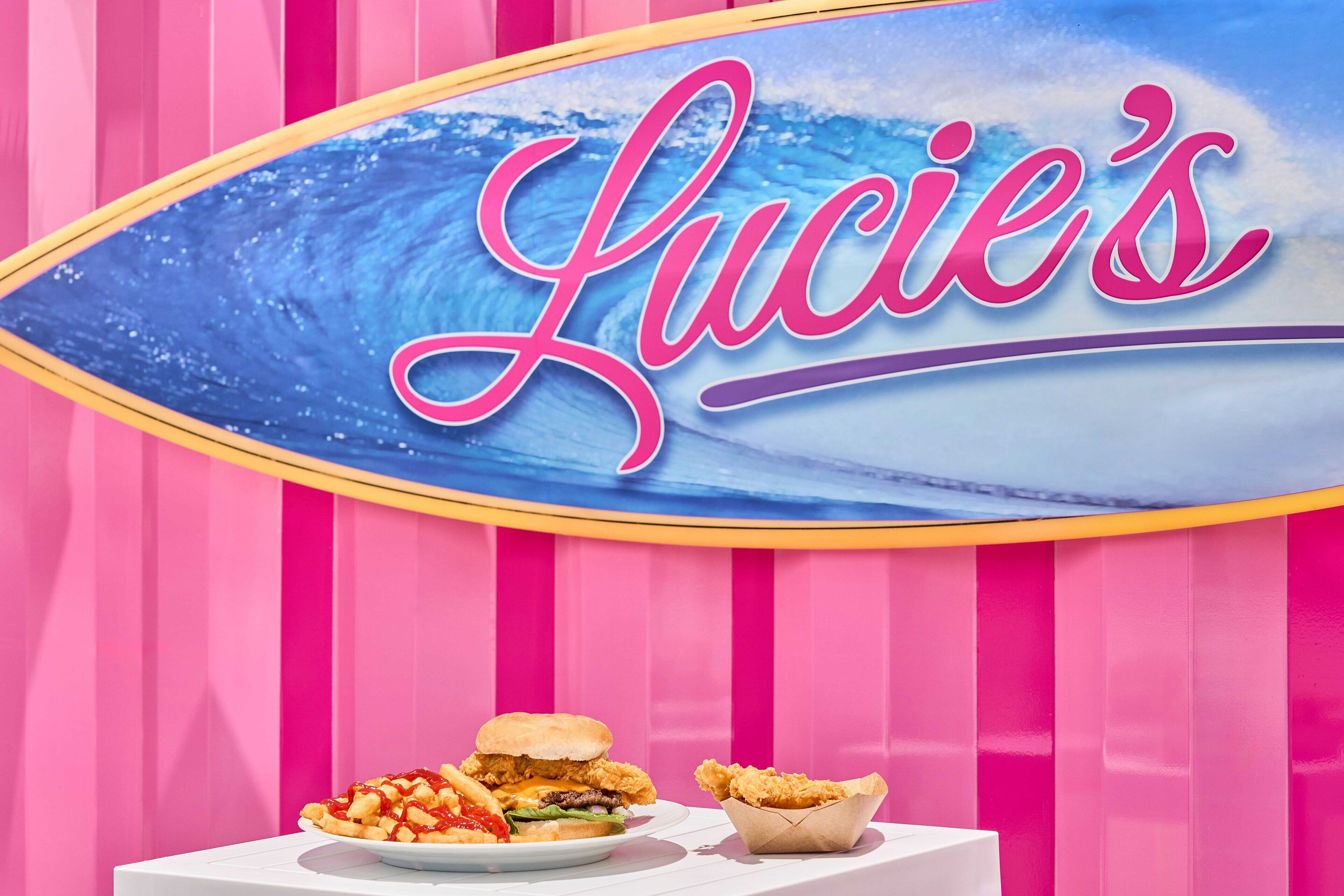 Une enseigne portant le nom « Lucie’s » et représentant un motif de planche de surf.