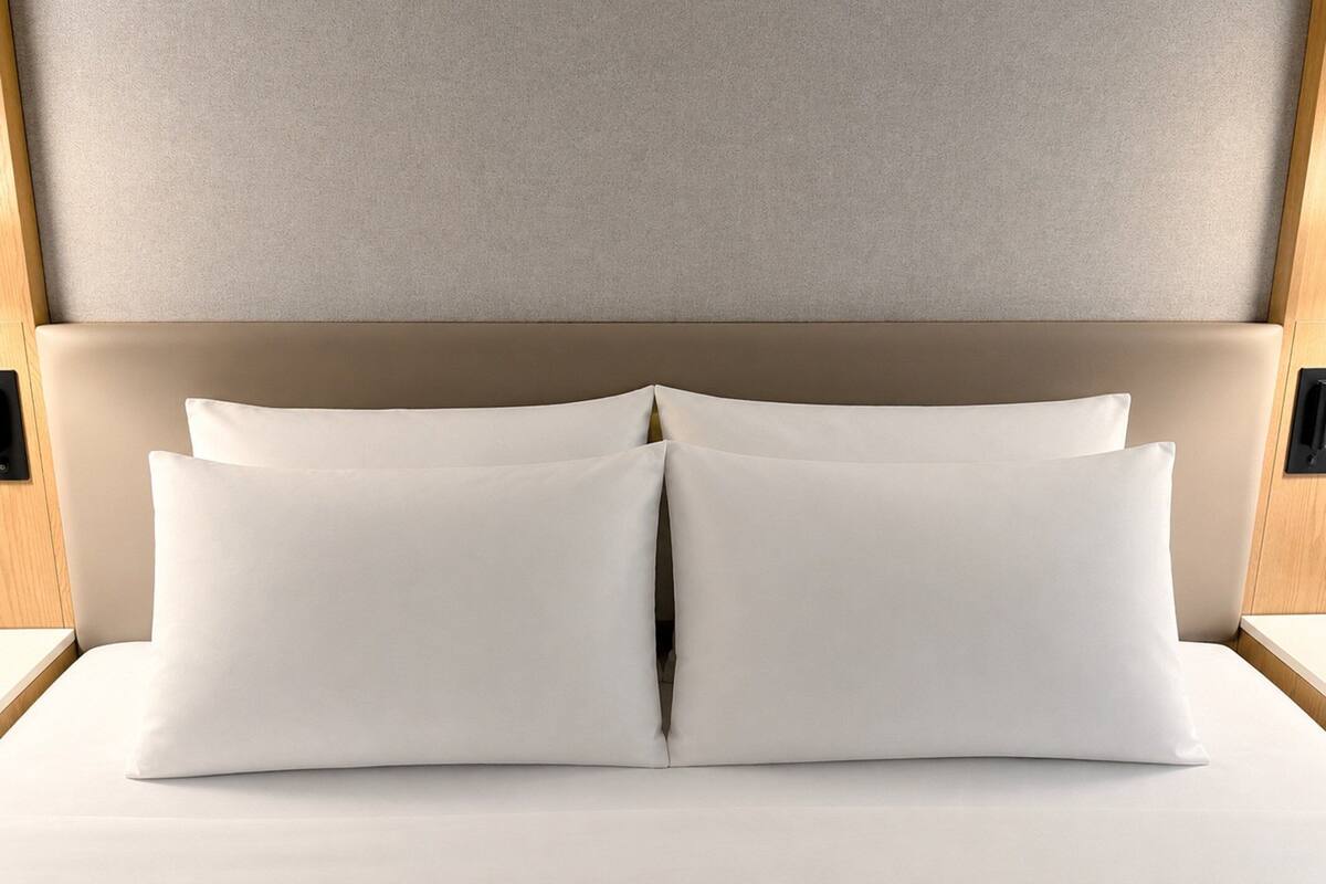 A bed with a headboard and two pillows.