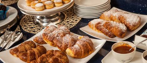 Una mesa de buffet con diversos pasteles y una taza de café.