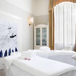 Relax in a serene spa room with a massage table, towels, and calming ambiance.