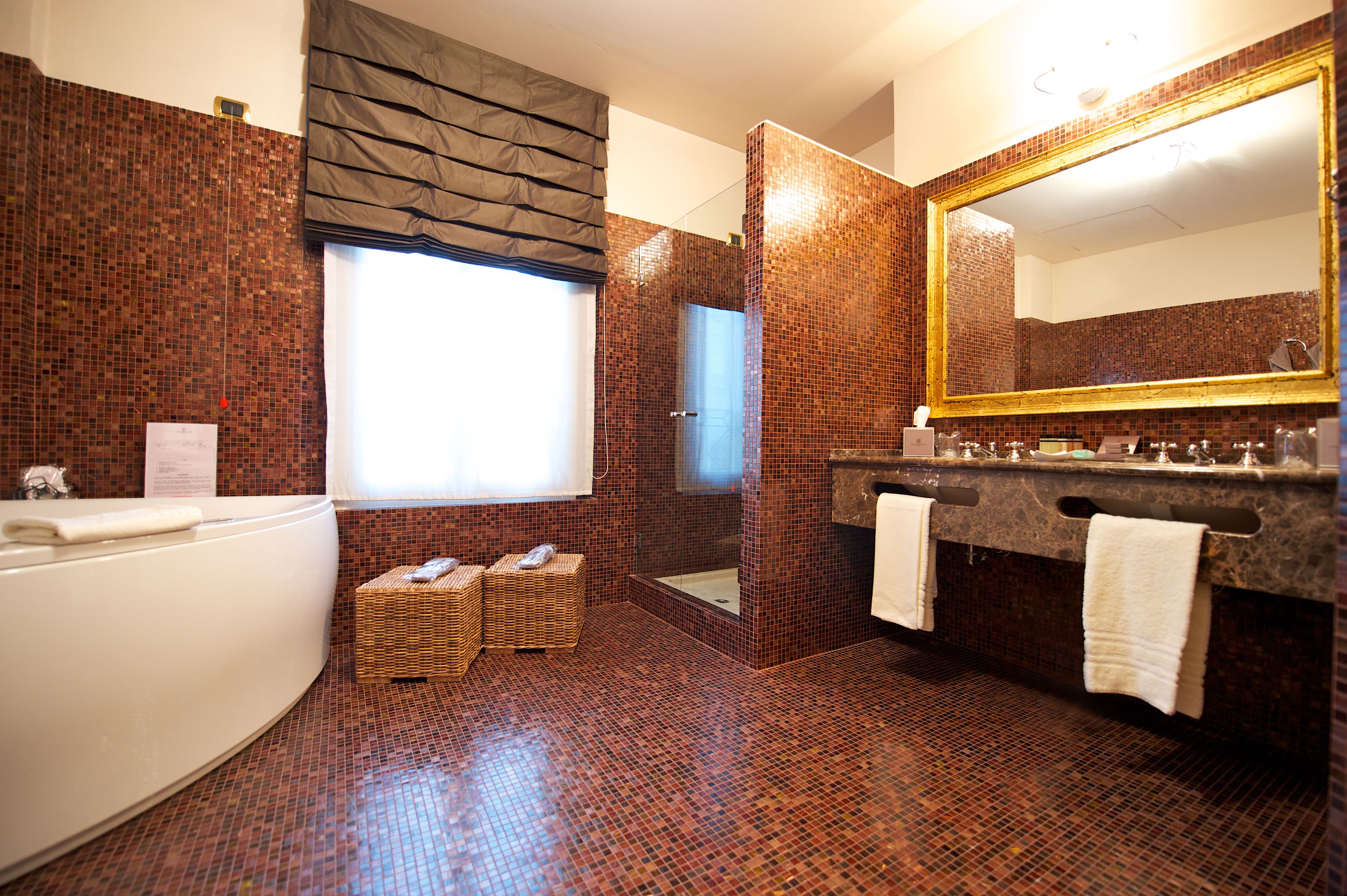 A modern bathroom with a large mirror, a bathtub, and a shower area.