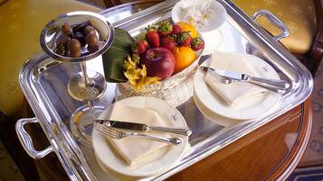 Un plateau avec un panier de fruits, des assiettes et des couverts.