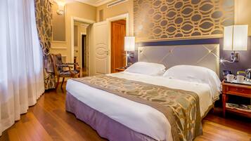 Una camera d'albergo con un letto grande, un comodino, una sedia e una parete decorata.