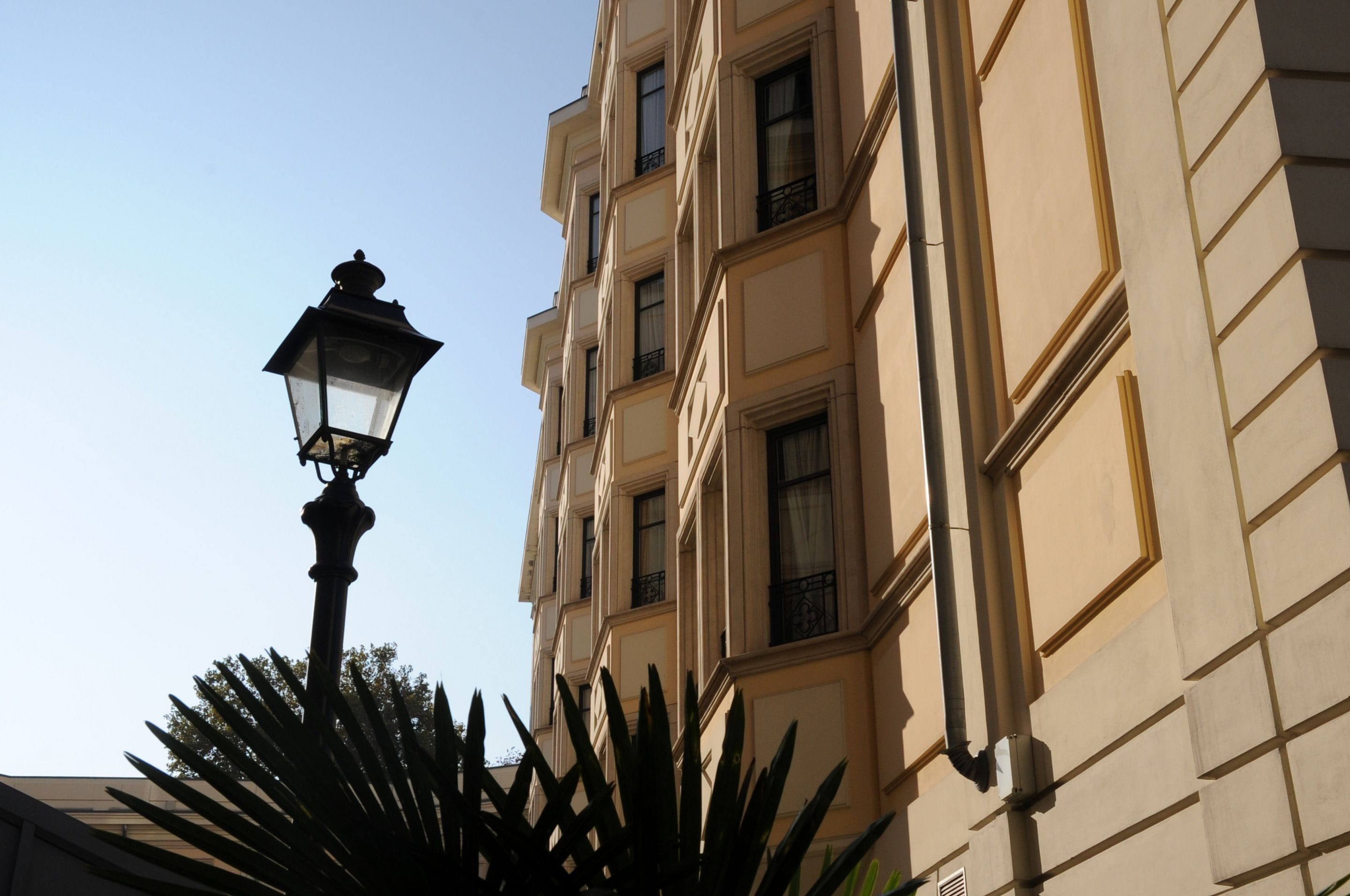 Ένα ψηλό κτίριο με πολλά παράθυρα και ένας φανός δρόμου μπροστά του.