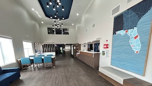 A spacious lobby with a reception desk, seating area, and a large wall map. - Holiday Inn Express Dania Beach Airport Area by IHG (Dania Beach)