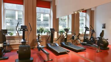 Un gimnasio con cintas de correr, elípticas y bicicletas estáticas.