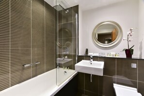 Een bad/douchecombinatie, een regendouche, designer toiletartikelen