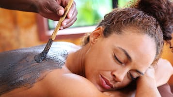 A person receiving a massage with a wooden tool on their back.