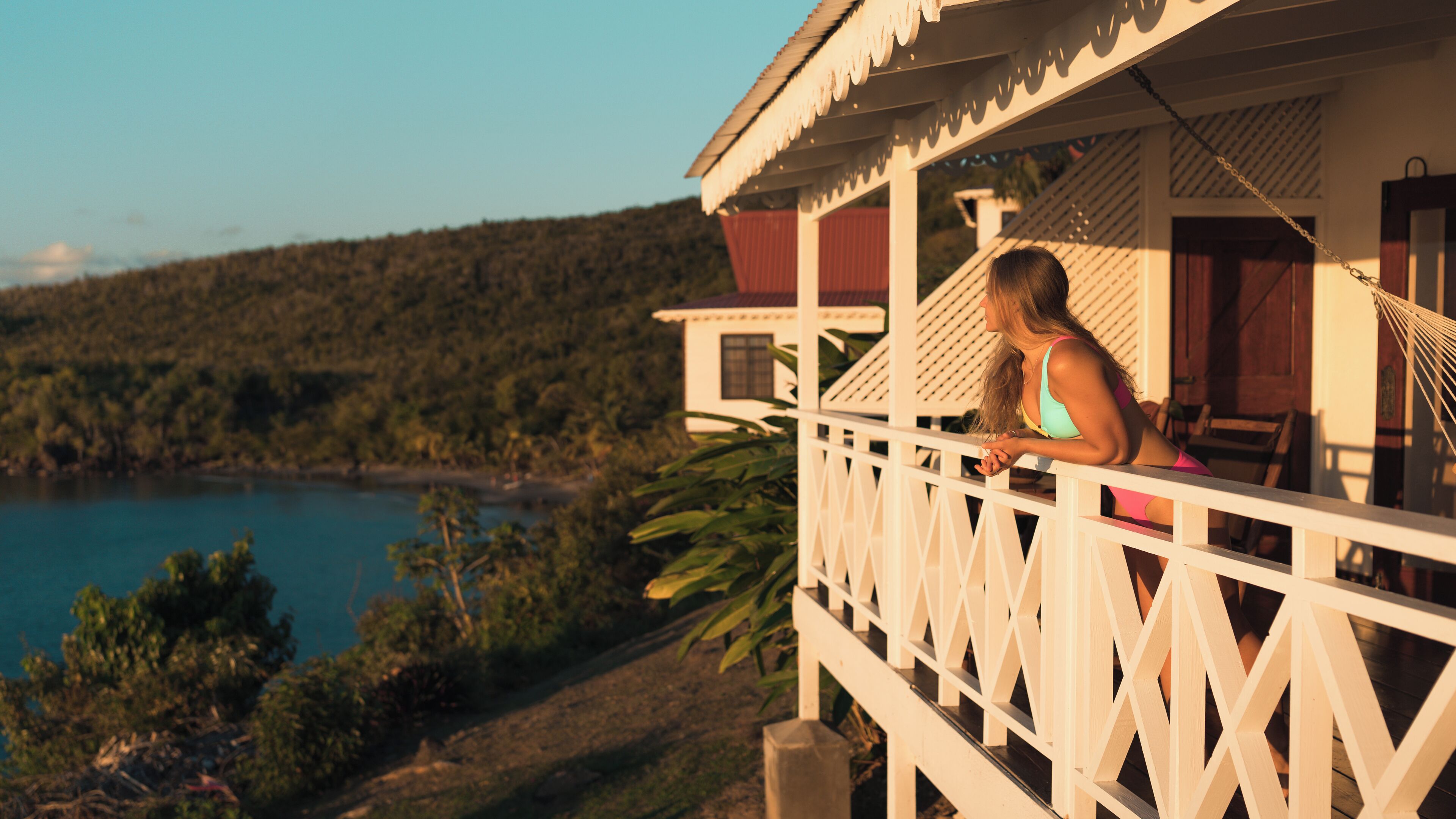 A balcony with a view of a beach and forest.