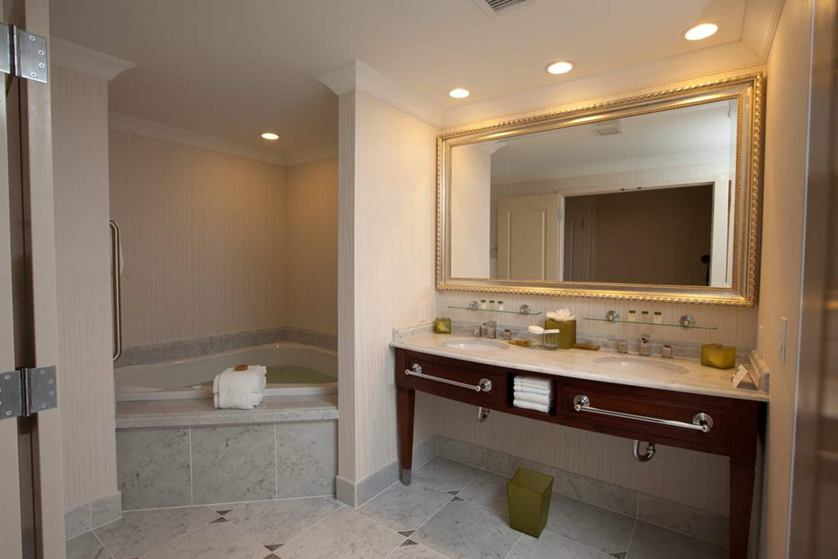 A bathroom with a bathtub, a vanity with a mirror, and a toilet.