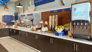 A breakfast bar with a coffee machine, cereal, and fruit display. - Holiday Inn Express West Sacramento by IHG (West Sacramento)