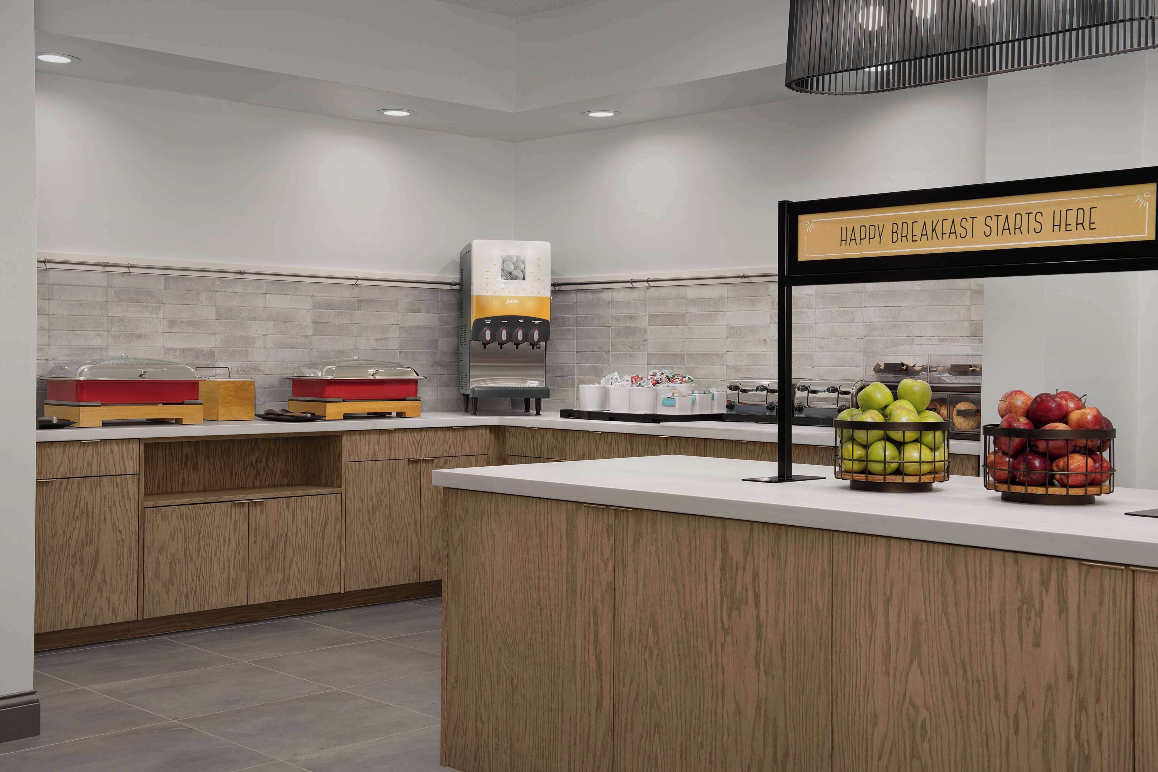 Un área de desayuno moderna con un letrero que dice "HAPPY BREAKFAST STARTS HERE".