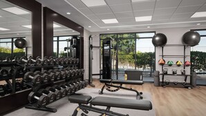 Uma academia moderna com equipamentos de musculação, bancos e kettlebells.
