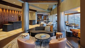 A spacious lobby with a reception desk, seating areas, and large windows. - Marriott Denver South at Park Meadows (Lone Tree)