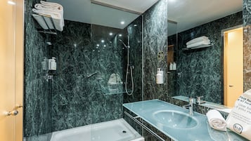 Habitación con 2 camas individuales | Baño | Ducha, artículos de higiene personal de diseño y secador de pelo