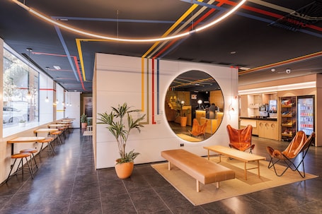 A modern interior with a long counter, seating area, and a circular mirror.