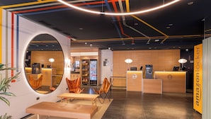 A modern interior with a reception desk, seating area, and lockers. - B&B Hotel Castellon (Castelló de la Plana)