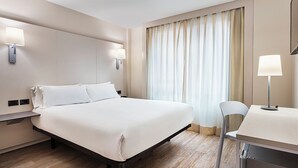 A hotel room with a bed, bedside lamps, a desk, and a chair. - B&B Hotel Castellon (Castelló de la Plana)