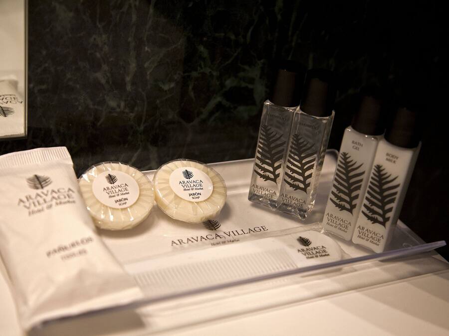 A display of Aravaca Village hotel amenities including soap, body milk, and bath gel.
