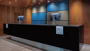 A reception desk with a black counter, two monitors, and a sign indicating "AC HOTEL MARBOTT". - AC Hotel La Línea by Marriott (La Línea de la Concepción)