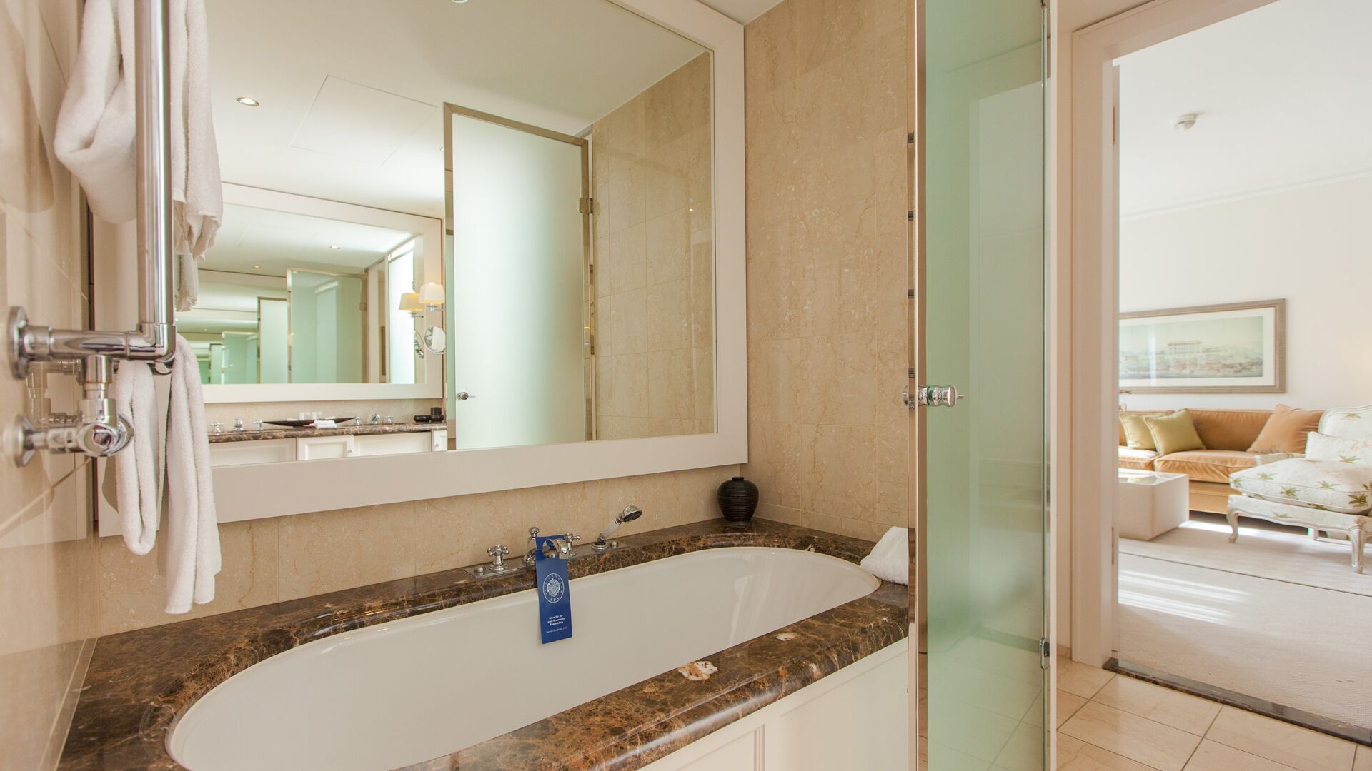 Une salle de bain moderne avec un grand miroir, une baignoire et une cabine de douche en verre.