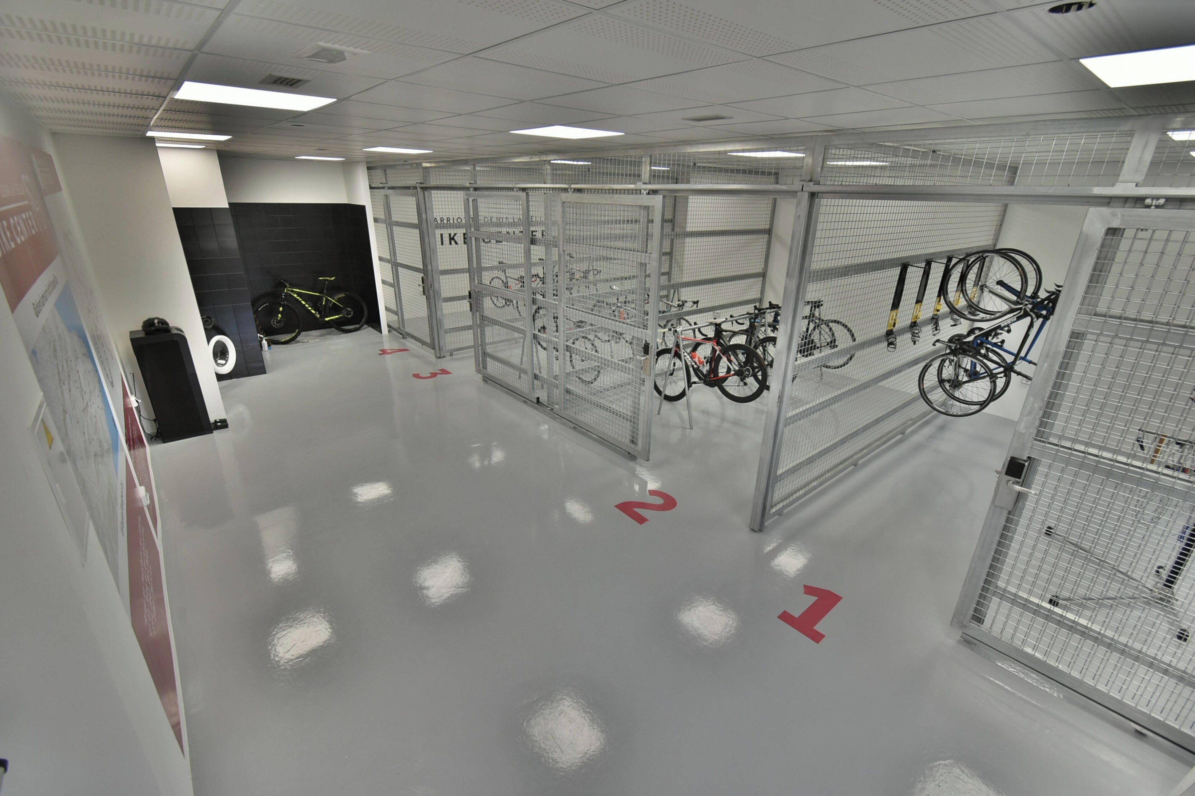 A bike storage area with multiple racks and a tire in the background.