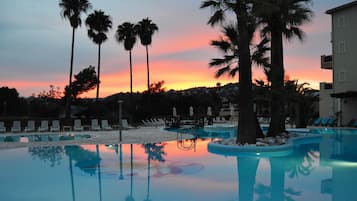 Una piscina al aire libre, sillones reclinables de piscina