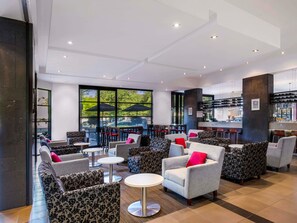 A spacious lounge area with multiple seating options, including sofas and armchairs, and a bar area with a wine rack. - Mantra Hindmarsh Square Adelaide (Adelaide)